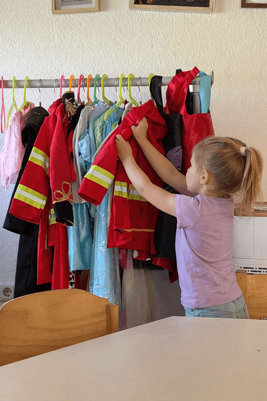 Kind sucht sich ein Verkleidungskostüm aus